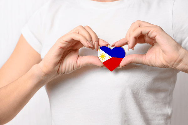 Hands holding a Philippine flag heart — representing BalaiCare's roots